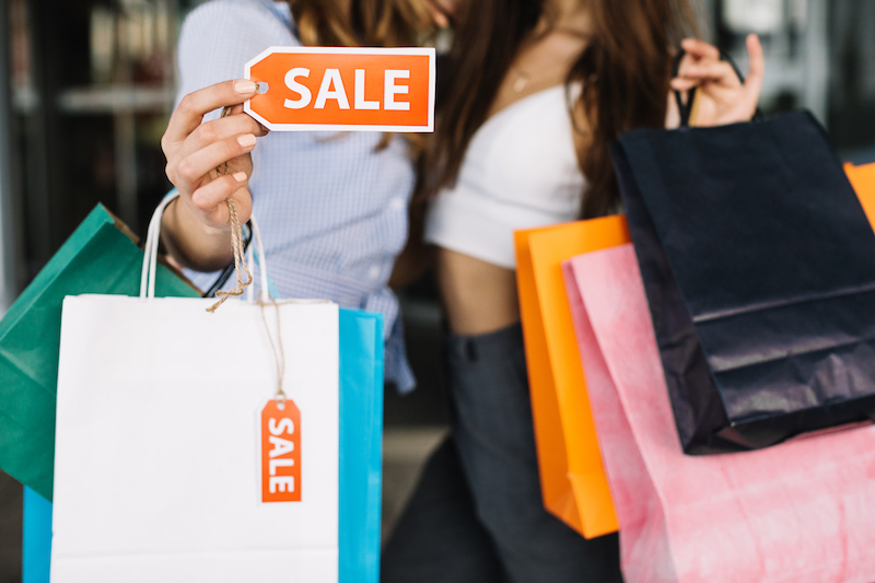 Två personer med shoppingpåsar och texten sale